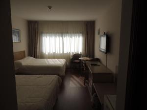 a hotel room with two beds and a desk at La Foret in Punta del Este