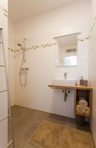 ein Bad mit einem Waschbecken und einem Spiegel in der Unterkunft Zehentner - Wein & Feriendomizil in Illmitz