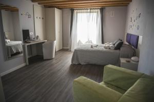ロナートにあるMichela BB & Relaisのベッドルーム1室(ベッド1台、椅子、窓付)