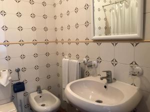 bagno con lavandino, servizi igienici e specchio di Residêncial Colaço a Alcoentre