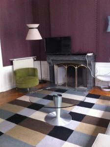 a living room with a table and a fireplace at Le Nid De La Chouette in Dijon