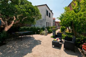 un patio con mesa, sillas y árboles en Ca' Del Pomo Grana' Al Roman, en Murano