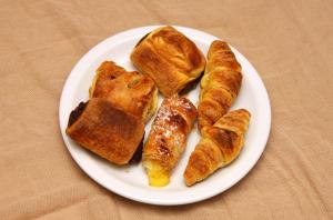 a plate of pastries and croissants on a table at Saint Constantine Hotel in Kos