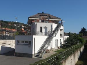 une maison blanche avec un escalier sur son côté dans l'établissement Bed & Breakfast 4U PARCHEGGIO INTERNO, à Chiavari