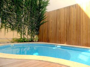 a swimming pool in front of a wooden fence at Appartement T4 Le Courbin in Bordeaux