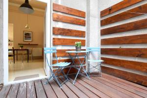 a wooden wall with two chairs and a table on a deck at Budget Apartment by Hi5 - Október 6 Str 4 in Budapest