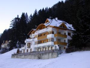 een gebouw bovenop een met sneeuw bedekte heuvel bij Hotel Garni Pradella in Ischgl