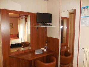 a room with a television and a table and a mirror at Pensione Genzianella in Alagna Valsesia