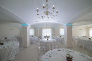 a room with white tables and chairs and a chandelier at Anima Antiqua Relais & Spa in Gioia Sannitica