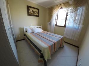 1 dormitorio con cama y ventana en C047 - Ed Las Condes, Centro de Bombinhas, en Bombinhas