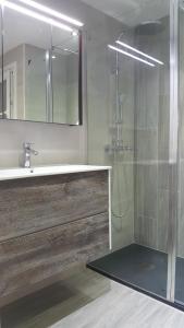 een badkamer met wastafel en douche met spiegel bij Apartament Marina Port Cambrils in Cambrils