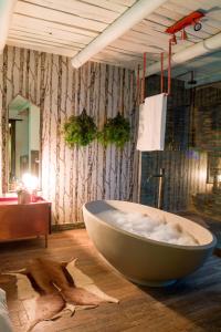 a bathroom with a large tub on a wooden floor at Bly B&B in Pretoria