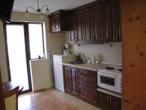 a kitchen with wooden cabinets and a white refrigerator at Guest House Vergie, Fully Private in Sapareva Banya