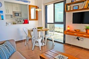 a kitchen and living room with a table and chairs at El Morche Beach in Torrox Costa +19 photos