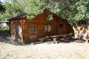 a log cabin with a picnic table in front of it at Ferme La Viste in La Roche-sur-le-Buis