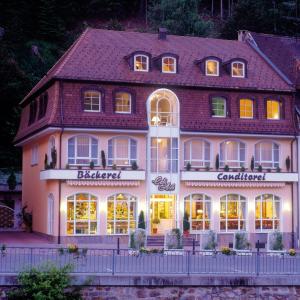 um grande edifício branco com um restaurante em frente em Hotel Garni Aich em St. Blasien