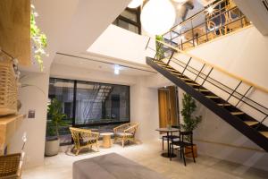 une chambre avec un escalier, une table et des chaises dans l'établissement Imano Tokyo Ginza Hostel, à Tokyo