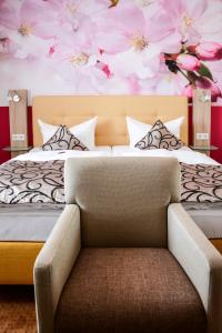 a bedroom with a bed with pink flowers on the wall at Hotel zur Insel in Werder