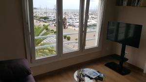een kamer met een groot raam met uitzicht op een haven bij Apartament Marina Port Cambrils in Cambrils