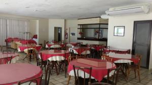 an empty dining room with red tables and chairs at Apartamento Guarujá in Guarujá