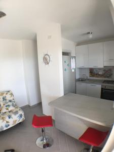 a kitchen with a counter and a red stool in a room at La casa del Tramonto in Praia a Mare