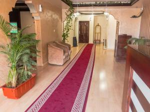 a living room with a red rug on the floor at Kasr Dama Furnished Apartments in Ḑubā