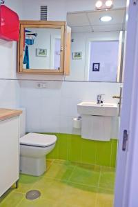 a bathroom with a toilet and a sink and a mirror at El Morche Beach in Torrox Costa
