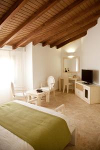 a bedroom with a bed and a desk and a television at AROHAZ Hotel & Restaurante in Zahora