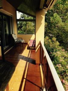 une terrasse couverte avec une chaise et des fenêtres dans l'établissement Villa Ecluses Mediterranee, à Portiragnes