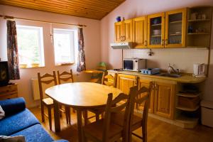 a kitchen with a wooden table and a kitchen with a table and chairs at Apartments Branisko in Smokovce
