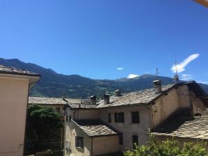 a group of buildings with mountains in the background at La maison du boulevard in Aosta