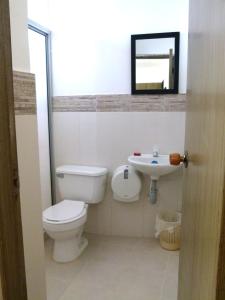 a bathroom with a toilet and a sink at Hotel Central in Sincelejo