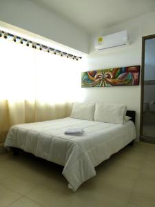Un dormitorio con una cama grande y una ventana en Hotel Central, en Sincelejo
