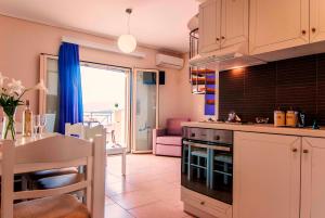 a kitchen with a table and a dining room at Thea Hotel - Studios & Suites in Marmari
