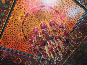 a painting of two men on a ceiling with flowers at Riad Moullaoud in Marrakesh