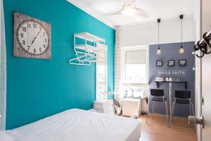 1 dormitorio con pared azul, reloj y escritorio en Marques Mini Hostel, en Lisboa