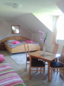 Un dormitorio con una cama y una mesa con un jarrón de flores en ApartmányDanielova en Česká Lípa