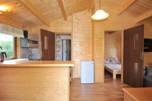 a kitchen and living room of a wooden house at Leśny Dworek in Darłowo