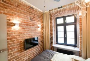 a brick wall in a bedroom with a tv and a brick fireplace at 2/3 APARTMENTS Old Town in Wrocław
