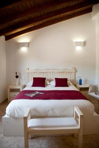 1 dormitorio con 1 cama blanca grande con almohadas rojas en AROHAZ Hotel & Restaurante en Zahora