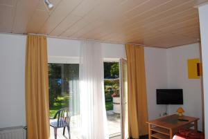 a living room with curtains and a sliding glass door at Landgasthof Gruss in Brilon