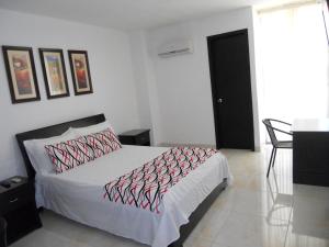 Ένα ή περισσότερα κρεβάτια σε δωμάτιο στο Hotel Cosmos Sincelejo