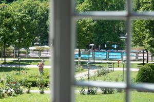 una ventana con vistas a un parque con piscina en Apartment Vila Golf, en Rogaška Slatina