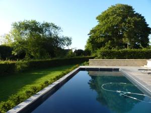 a swimming pool in a yard with trees at Chambres d'Hôtes Le Petit Sully in Sully