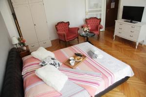 a room with a bed with a table and red chairs at London Apartment in Belgrade