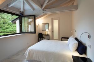 a bedroom with a white bed and a window at Finca Portizuelo in Luarca