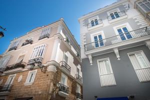 dwa wysokie budynki obok siebie w obiekcie Casa Margot Cádiz Grupo AC Gestión w Kadyksie