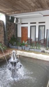 een fontein in het midden van een plas water bij RF Hotel in Puncak