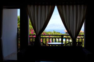 einen Blick aus dem Fenster eines Balkons mit einem Tisch in der Unterkunft Ropik & Alik Home Stay in Uluwatu