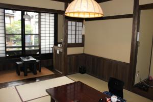 a living room with a table and a lamp at Kurokawa Onsen Yama no Yado Shinmeikan in Minamioguni
